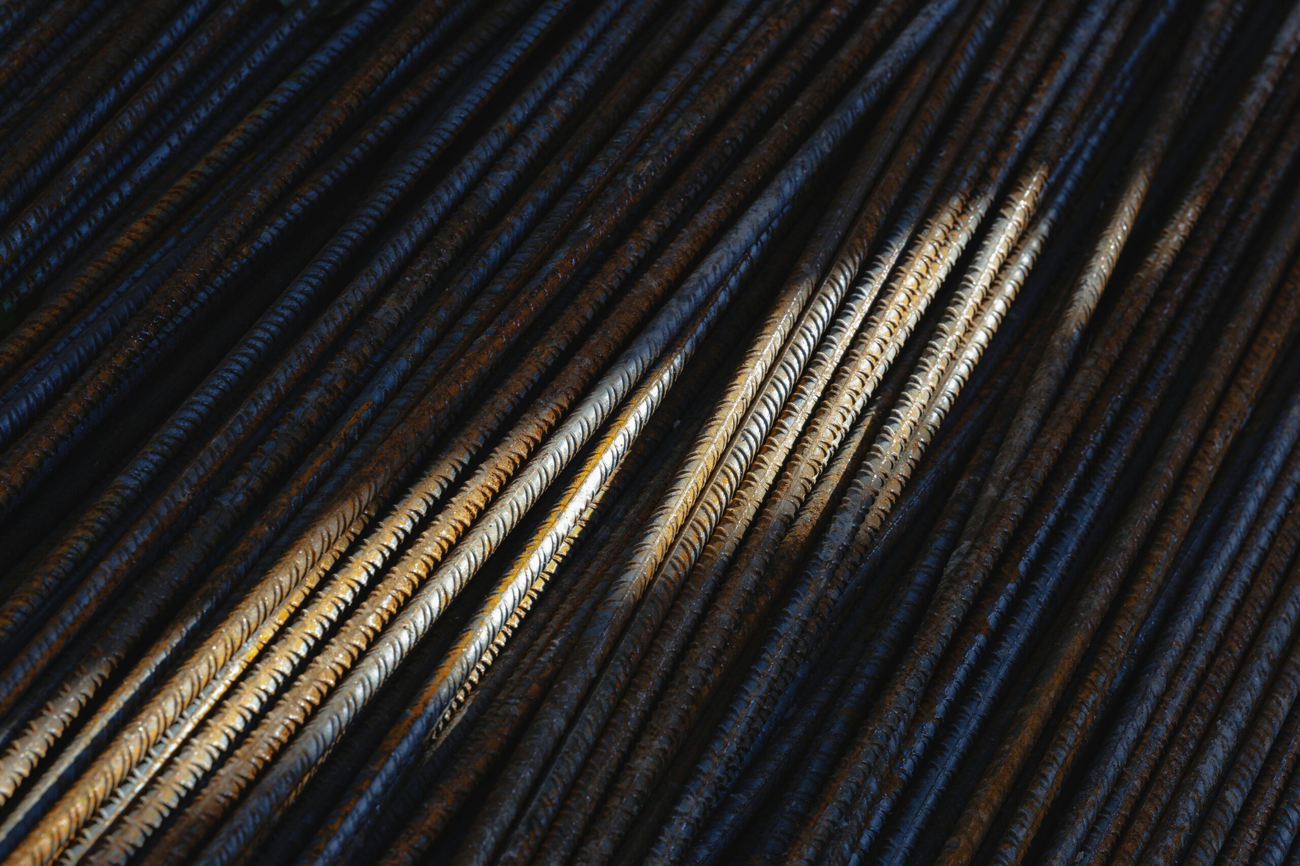 Artistic close-up of rusty steel rebars with dramatic lighting and texture.